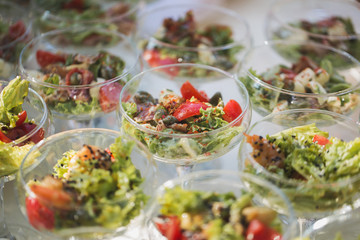 Reception at the wedding. Snacks and wine glasses on a glass table.