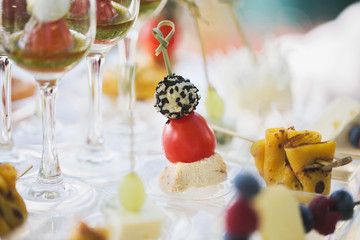 Reception at the wedding. Snacks and wine glasses on a glass table.