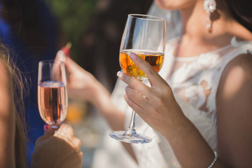 bride in white dress holds a glass of champagne in her hand