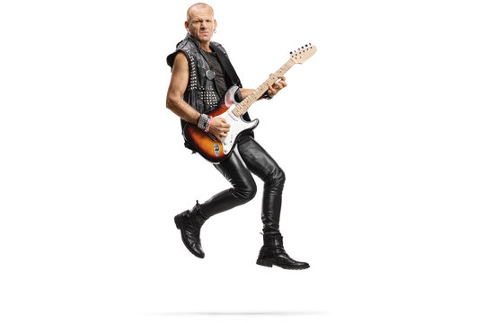 Male musician jumping and playing an electric guitar