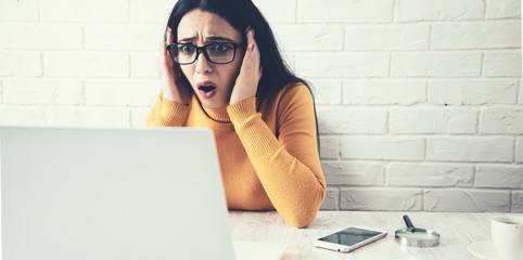 sad and surprised woman with computer