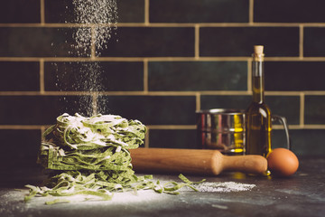 Italian pasta food background. Vegan italian pasta fresh with spinach (Spinach Fettuccine Alfredo Pasta) on a dark background. Old kitchen background. Copy space