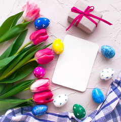 Happy ester. color eggs with tulips and gifs on grey background top view