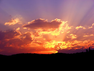 Vibrant and colorful purple sunset with silhouette of mountain