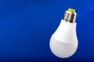 Different bulbs fall down. Electric lighting. Blurred background. Power saving LED lamps in comparison with incandescent lamps. Environmental friendliness.