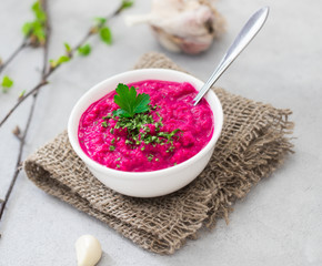Russian appetizer horseradish with beetroot in a bowl in rustic style on a light background