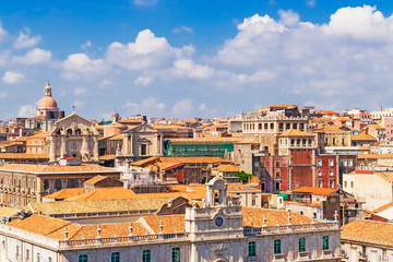 Naklejka na ściany i meble Aerial skyline panoramic view of Catania in September, old town featuring brown and yellow roofs with Mount Etna at background. Sicily, Italy 