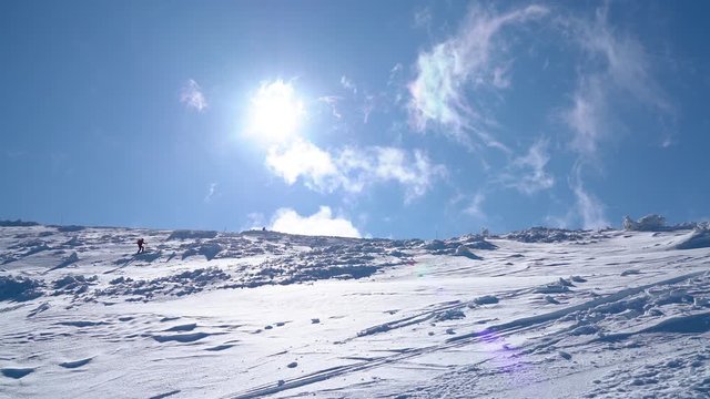 Ski mountaineering (skimo) 4K footage in winter Slovakian Tatra mountains. Skier ascending a summit wide angle shot with blue sky and white snow. Various Earth climates and active people concept video