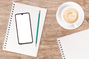 Phone and coffee on a vintage wooden background. Technology concept background. White screen phone copy space. Concept photos of desks / commercial backgrounds.