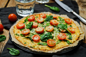 Cauliflower pizza crust with tomato and spinach