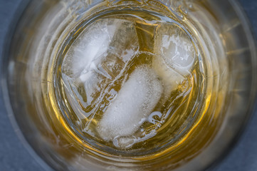 Glas mit Whisky on the Rocks als Hintergrund im Detail