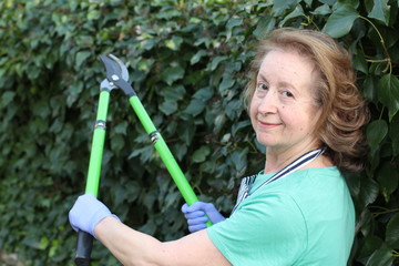Senior woman pruning ivy manually