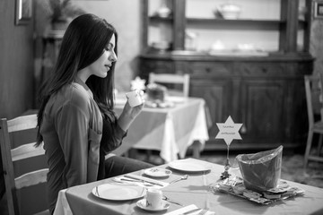 Ragazza italiana bruna con camicia rossa fa colazione all'italiana
