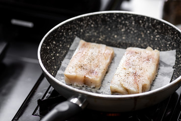 Fish fillet cod white meat fry on parchment in oil in pan