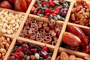 Dried fruits, various nuts and seeds in wooden box.