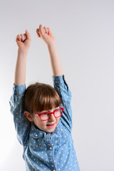 Portrait of cheerful young girl with arms raised. Happy success childe win opportunity. Young smiling girl holding hands up, looking at camera.