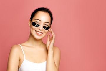 Asian beauty model concept. Attractive young woman applying  black eye patches