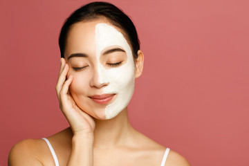 Young asian woman applying beauty face mack. Clean and care skin concept.