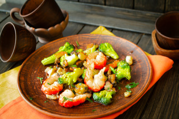 Grilled shrimps and fresh green salad served for lunch on rustic table
