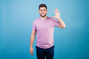 smiling man showing five fingers isolated on blue background