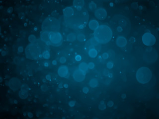 Abstract blue bokeh texture on black background.