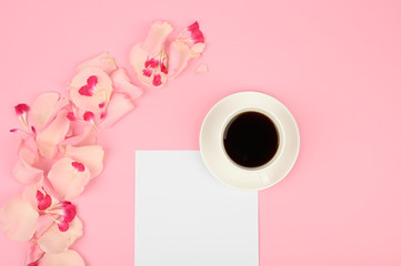 The concept of day planning. A cup of coffee, white card, pink flowers. Flat lay