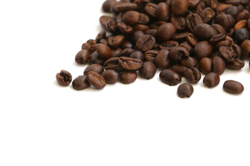 Isolated coffee beans scattered on a white surface with space for text