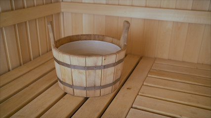 Fototapeta na wymiar Interior details Finnish sauna steam room with traditional sauna accessories basin scoop. Traditional old Russian bathhouse SPA Concept. Relax country village bath concept. Wooden basin in the sauna