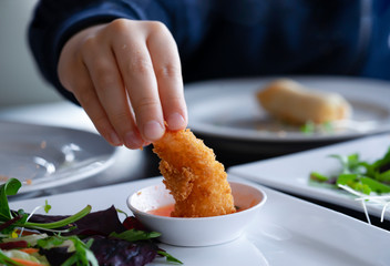 Kid hand holding fried shrimp and dipping with cocktail sauce, Home made deep fried coconut shrimp with sweet sauce, Snack menu for kid, Asian food