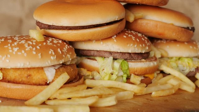 portion of unhealthy food, fast food, stack of burgers, fries rotating, turning