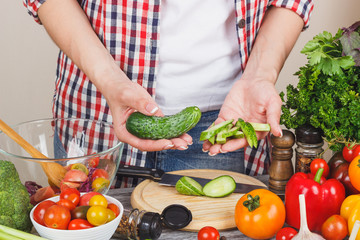 Woman cooks at the kitchen, body part