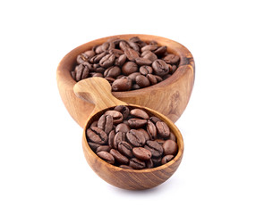 Coffee beans in a wooden spoon on white background.