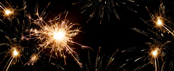 Silvester festive background - Sparkler in the dark black night, with space for text