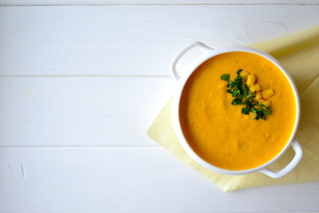 Corn soup with parsley and bread on a white background