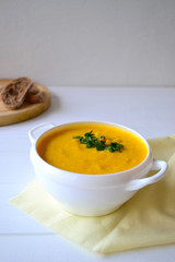 Corn soup with parsley and bread on a white background