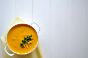 Corn soup with parsley and bread on a white background