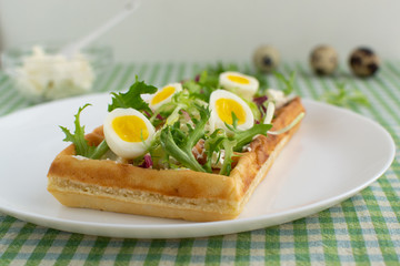 Belgian waffles with boiled quail eggs, mix of green leaves and cheese.