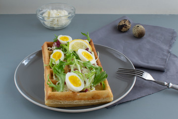 Belgian waffles with boiled quail eggs, mix of green leaves and cheese.