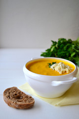 Corn soup with parsley and bread on a white background
