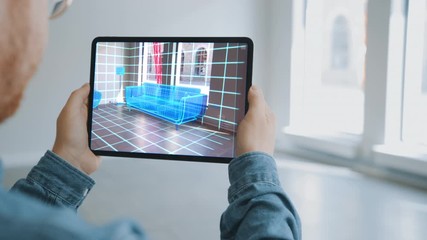 Decorating Apartment: Man Holding Digital Tablet with AR Interior Design Software  Chooses 3D Furniture for Home. Man Pick Sofa, Table, Lamp for Living Room. Over Shoulder Screen Shot with 3D Render - Powered by Adobe