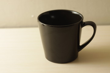 black porcelain cup on a bright wooden table