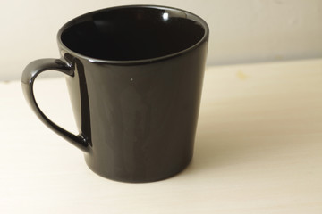 black porcelain cup on a bright wooden table