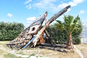 Fototapeta na wymiar Relitto di una vecchia nave in legno esposto alla Cala (porto) di Palermo. Sicilia