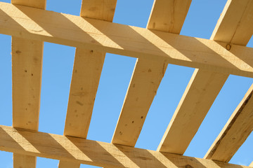 Wood board assembled on construction site. New frame structure of building. Scaffolding framework made from natural materials. Wooden floor or ceiling. Elements and components of the construction.