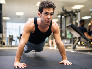 Fototapeta na wymiar Man doing push ups in a gym