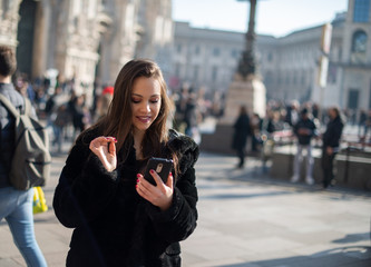 Woman using her smartphone while walking in a city