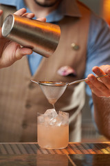 Fototapeta na wymiar Expert barman is making cocktail at night club, close-up.