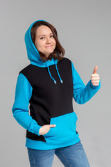 Woman in black and blue hoodie, showing thumb up satisfied, mockup for logo or branding design