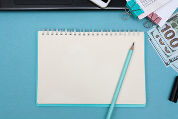 Notebook with place for text and pencil on a blue desktop of a businessman