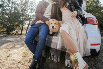 The guy with the girl spend time with the Corgi.
